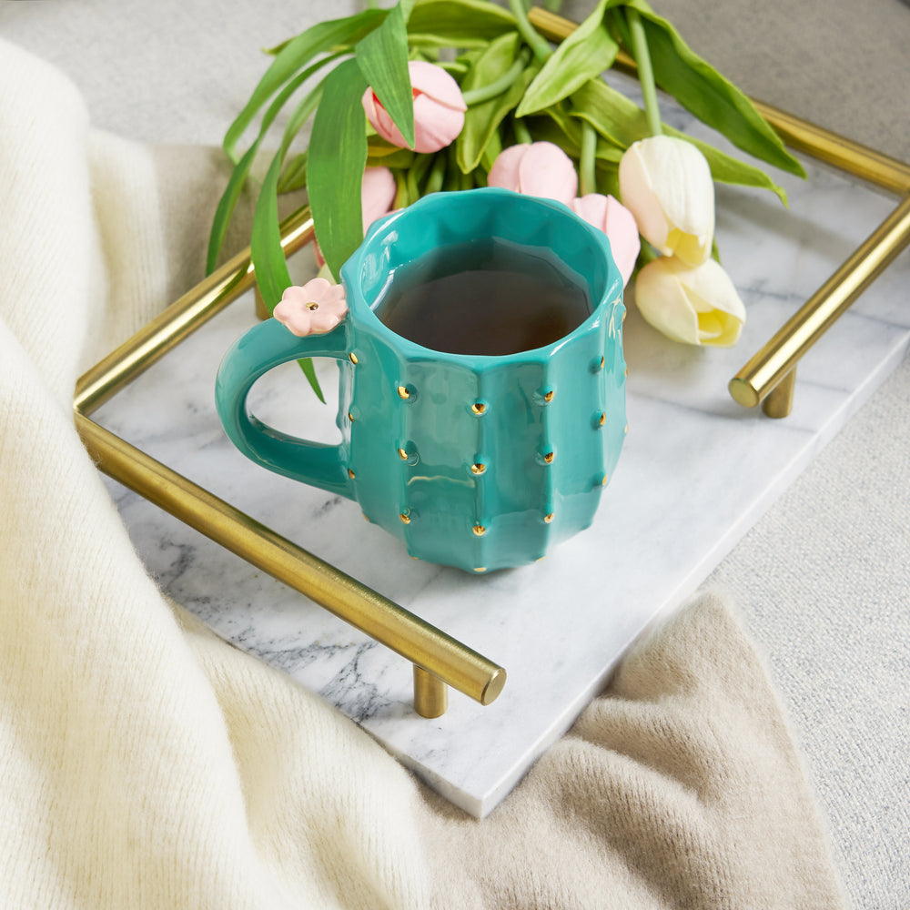 GREEN CERAMIC WITH GOLD DETAILS - Green ceramic and metallic gold “spikes”  create a beautiful contrast that highlights the cactus design. A pink 3D flower blooms on the handle for a charming detail that’ll make any plant lover smile.